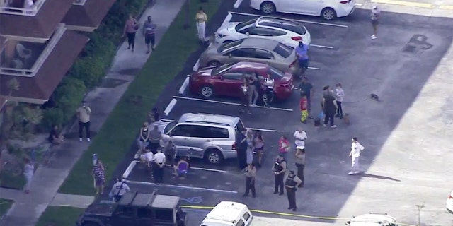 Officers and residents outside the Miami-Dade apartment building where part of the roof broke off and collapsed Thursday afternoon.