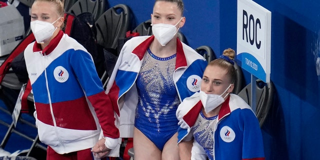 Teammates Liliia Akhaimova, right, Vladislava Urazova, center and Viktoriia Listunova watch the performance of Angelina Melnikova of the Russian Olympic Committee as she performs on the floor during the artistic gymnastics women's final at the 2020 Summer Olympics, Tuesday, July 27, 2021, in Tokyo. (AP Photo/Gregory Bull)