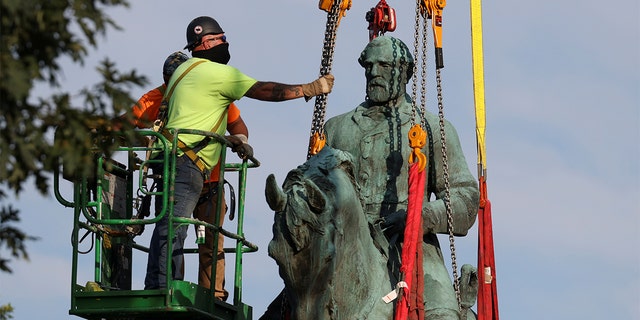 Workers remove a statue of Confederate General Robert E. Lee, after years of a legal battle over the contentious monument, in Charlottesville, Virginia, the U.S, July 10, 2021. REUTERS/Evelyn Hockstein