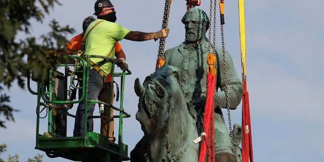 Workers remove a statue of Confederate General Robert E. Lee, after years of a legal battle over the contentious monument, in Charlottesville, Virginia, the U.S, July 10, 2021. REUTERS/Evelyn Hockstein