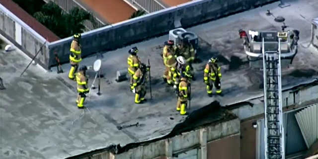 Firefighters on the roof of a Northwest Miami-Dade apartment building roof collapse Thursday.