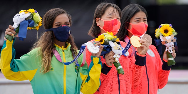 From left, silver medalist Rayssa Leal of Brazil, gold medalist Momiji Nishiya of Japan, center, and bronze medalist Funa Nakayama of Japan show their medals won in the women's street skateboarding finals at the 2020 Summer Olympics, Monday, July 26, 2021, in Tokyo, Japan. (AP Photo/Ben Curtis)