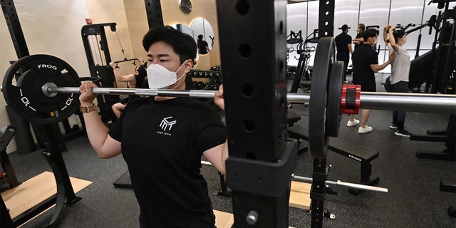People exercise at a gym in Seoul on July 13, 2021, as South Korea announced implementation of level 4 social distancing measures amid concerns of a fourth wave of the coronavirus pandemic. 