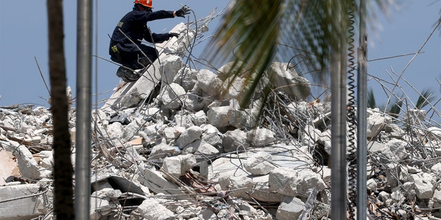 SURFSIDE, FLORIDA - JULY 09: A rescuer guides an excavator to dig the remains of the collapsed 12-story Champlain Towers South condo building on July 09, 2021 in Surfside, Florida.  (Photo by Anna Moneymaker / Getty Images)