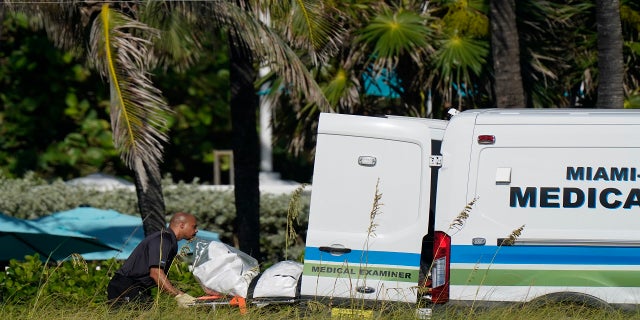 Workers load a stretcher with remains extricated from the rubble into a Miami-Dade County Medical Examiner van, near the Champlain Towers South condo building on Friday. (AP)
