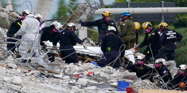 Rescuers are moving a stretcher with the remains found at the site of the collapse of the Champlain Towers South condom building in Surfaid, Fla., On Monday. (AP)