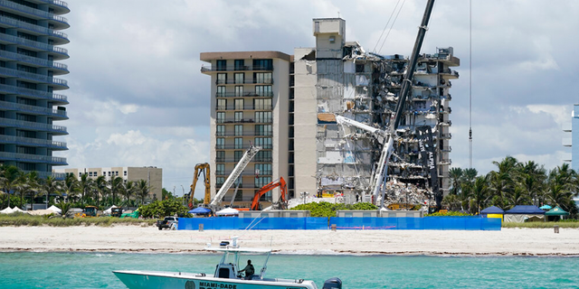 A Miami-Dade County Police boat patrols in front of the Champlain Towers South condo building, where search and rescue efforts continue more than a week after the building partially collapsed, Friday, July 2, 2021, in Surfside, Fla.