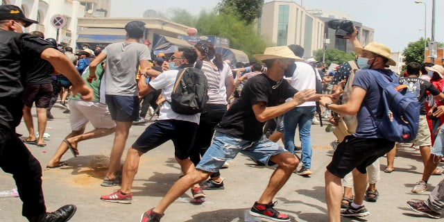 A Tunisian policeman brawls with protesters during a protest in Tunis, Tunisia, on Sunday.