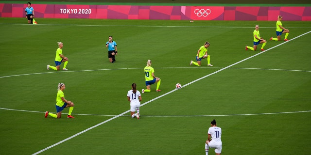 The players kneel before the opening match of the women's soccer first round between the United States and Sweden at the Tokyo 2020 Olympic Games in Tokyo, Japan on Wednesday, July 21, 2021. The games will be the first in modern history to unfold without spectators, after Tokyo entered another state of emergency that will last throughout the tournament.  Photographer: Noriko Hayashi / Bloomberg via Getty Images