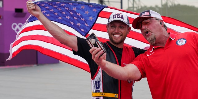 Gold medalist Vincent Hancock, of the United States, takes a selfie with his coach after the men's skeet at the Asaka Shooting Range in the 2020 Summer Olympics, Monday, July 26, 2021, in Tokyo. (Associated Press)