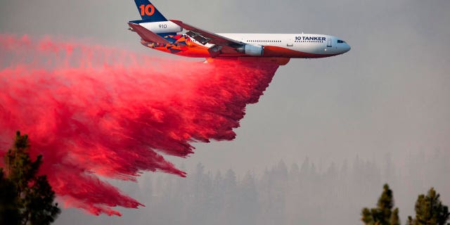 In this photo provided by the Bootleg Fire Incident Command, a DC-10 tanker drops retardant over the Bootleg Fire in southern Oregon, Thursday, July 15, 2021. (Bootleg Fire Incident Command via AP)