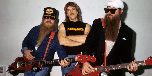 Dusty Hill, Frank Beard and Billy Gibbons - posed, group shot, backstage at Monsters Of Rock, Hot Rod shaped guitars, novelty guitars.