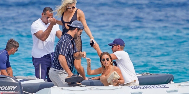 Alex Rodriguez helps a mystery blonde woman from a motorboat while in the South of France.