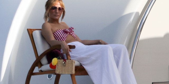 Jennifer took in the sunshine wearing her skimpy striped bikini top showing off her toned tummy and lounging on their $130M yacht.