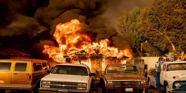 Flames consume a home as the Sugar Fire, part of the Beckwourth Complex Fire, tears through Doyle, Calif., on Saturday, July 10, 2021. Pushed by heavy winds amid a heat wave, the fire came out of the hills and destroyed multiple residences in central Doyle. (AP Photo/Noah Berger)