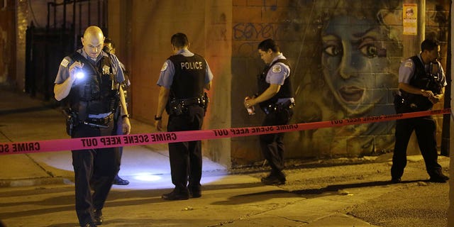 Chicago Police officers investigate the crime scene where a man was shot in the alley in the Little Village neighborhood on July 2, 2017 in Chicago, Illinois.  A South Carolina sheriff's deputy was shot and an armed suspect was killed in July, authorities said. 