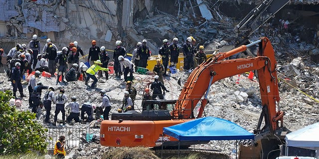 Search and rescue personnel work atop the rubble at the Champlain Towers South condo building, where scores of victims remain missing more than a week after it partially collapsed, Friday, July 2, 2021, in Surfside, Fla. (Associated Press)