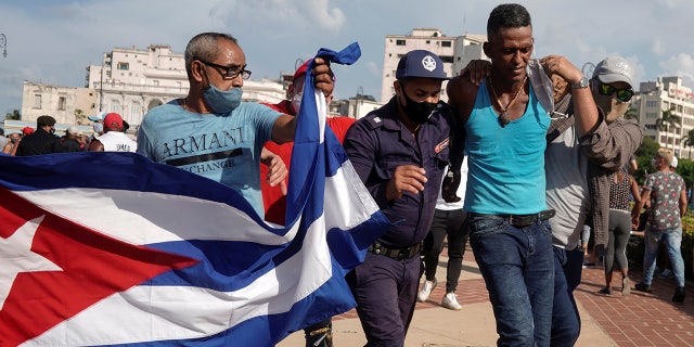 Police detain a person during protests against and in support of the government, amidst the coronavirus disease (COVID-19) outbreak, in Havana, Cuba July 11, 2021.