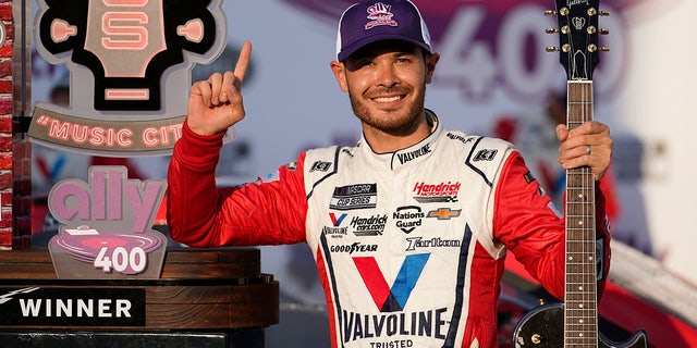 FILE - Kyle Larson celebrates with the winner's guitar and trophy after winning a NASCAR Cup Series auto race at Nashville Superspeedway in Lebanon, Tenn., in this Sunday, June 20, 2021, file photo. Rick Hendrick gave Kyle Larson a second chance in NASCAR because Hendrick Motorsports had wanted him in its lineup for years. Now that Hendrick has his man, he's locked Larson down for two more seasons with full sponsorship.  Hendrick on Wednesday, July 14, told his 93 dealerships that the hottest driver in motorsports signed a contract extension through 2023 and Larson will be fully sponsored by HendrickCars.com. (AP Photo/Mark Humphrey, File)