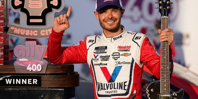 FILE - Kyle Larson celebrates with the winner's guitar and trophy after winning a NASCAR Cup Series auto race at Nashville Superspeedway in Lebanon, Tenn., in this Sunday, June 20, 2021, file photo. Rick Hendrick gave Kyle Larson a second chance in NASCAR because Hendrick Motorsports had wanted him in its lineup for years. Now that Hendrick has his man, he's locked Larson down for two more seasons with full sponsorship. Hendrick on Wednesday, July 14, told his 93 dealerships that the hottest driver in motorsports signed a contract extension through 2023 and Larson will be fully sponsored by HendrickCars.com. (AP Photo/Mark Humphrey, File)