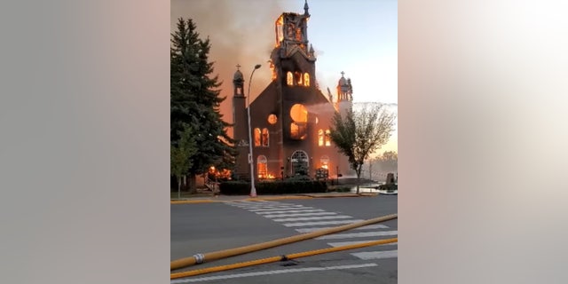 As chamas engolfam uma igreja católica enquanto os bombeiros trabalham para extinguir o incêndio na paróquia de Saint Jean Baptiste em Moraineville, Alberta, Canadá