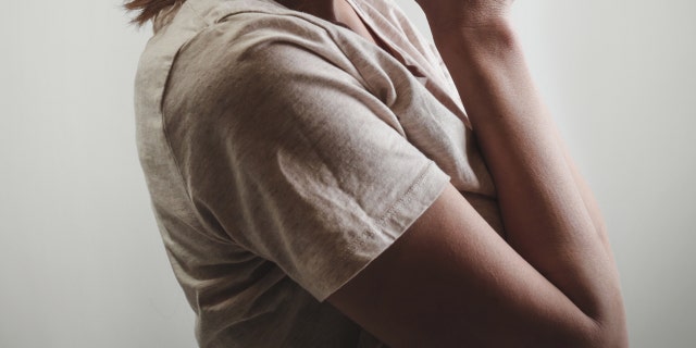 File portrait of depressed woman, covering face with her hands, side view