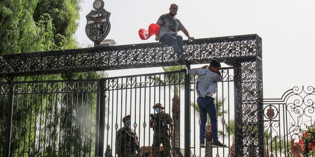 Tunisian soldiers guard the main entrance to parliament as protesters gather outside the gate in Tunis, Tunisia, Monday, July 26, 2021. (AP Photo / Hedi Azouz)