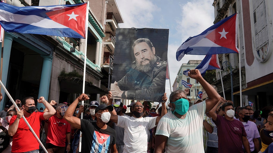Government supporters hold a photograph of Cuba's late President Fidel Castro during protests against and in support of the government, amidst the coronavirus disease (COVID-19) outbreak, in Havana, Cuba July 11, 2021. REUTERS/Alexandre Meneghini