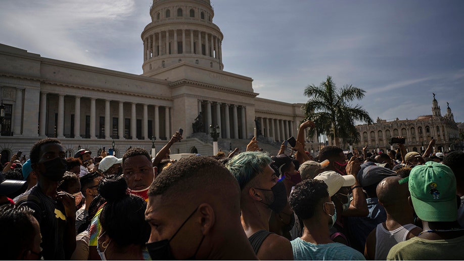 People protest in front of the Capitol in Havana, Cuba, Sunday, July 11, 2021. Hundreds of demonstrators went out to the streets in several cities in Cuba to protest against ongoing food shortages and high prices of foodstuffs, amid the new coronavirus crisis. (AP Photo/Ramon Espinosa)