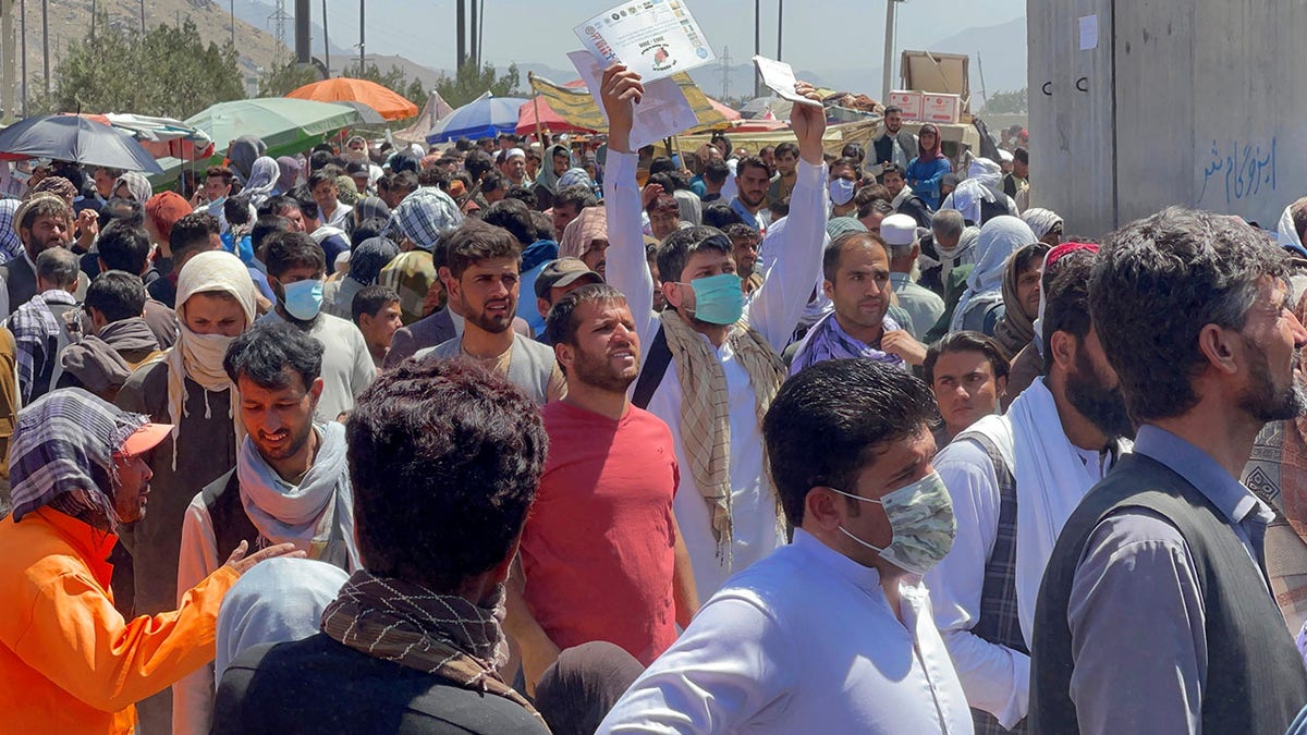 Crowds of people show their documents to U.S. troops outside the airport in Kabul, Afghanistan Aug. 26, 2021.