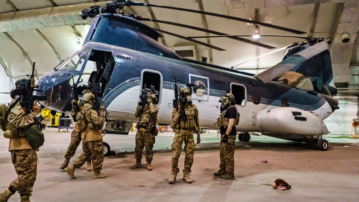 Taliban fighters from the Fateh Zwak unit, wielding American supplied weapons, equipment and uniforms, storm into the Kabul International Airport to secure the airport and inspect the equipment that was left behind after the U.S. Military have completed their withdrawal, in Kabul, Afghanistan, Tuesday, Aug. 31, 2021. (MARCUS YAM / LOS ANGELES TIMES)