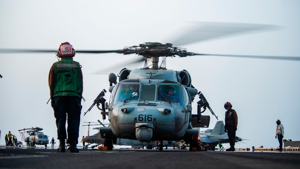 In this photo provided by the U.S. Navy, sailors on board an MH-60S Seahawk helicopter on the flight deck of aircraft carrier USS Ronald Reagan prepare to head to an oil tanker that was attacked off the coast of Oman in the Arabian Sea on Friday, July 30, 2021. An attack on an oil tanker linked to an Israeli billionaire killed two crew members off Oman in the Arabian Sea, authorities said Friday, marking the first fatalities after years of assaults targeting shipping in the region. (Mass Communication Specialist 2nd Class Quinton A. Lee/U.S. Navy, via AP)