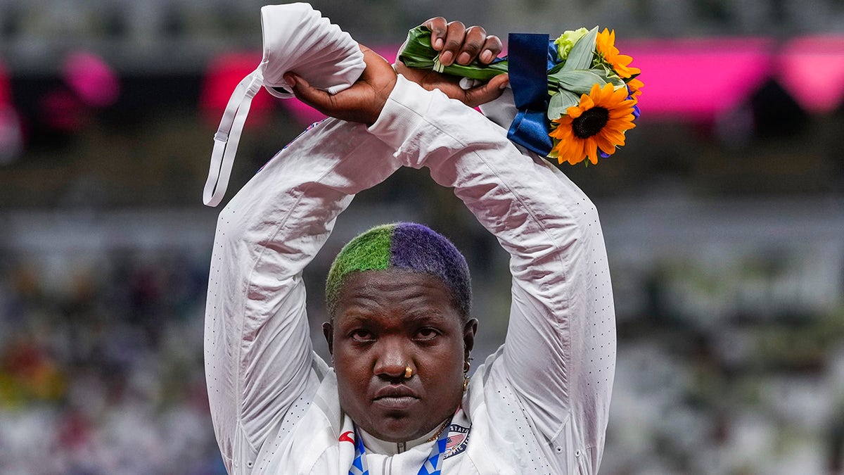 Raven Saunders makes an "X" gesture above her head