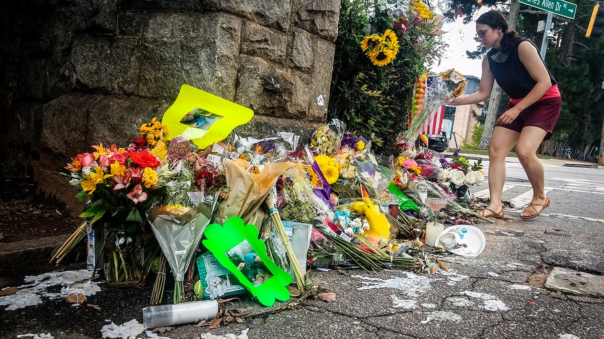 A makeshift memorial to Katherine Janness is seen at the entrance to Piedmont Park on Sunday, Aug. 1, 2021, in Atlanta. Janness, 40, was found stabbed to death in the park in the early hours of July 28.  Police say her dog was also killed at the scene. No arrests have been made and the FBI is assisting local authorities in the case. (AP Photo/Ron Harris)