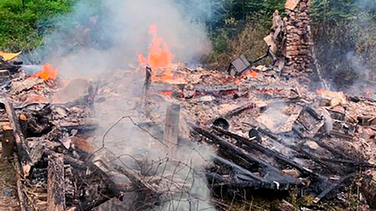 In this photo provided by the Canterbury (New Hampshire) Fire Department, smoke rises Wednesday, Aug. 4, 2021, from the burnt remains of a cabin in Canterbury, N.H., inhabited by 81-year-old David Lidstone, who for 27 years has lived in the woods of New Hampshire along the Merrimack River in the once small, solar-paneled cabin.
