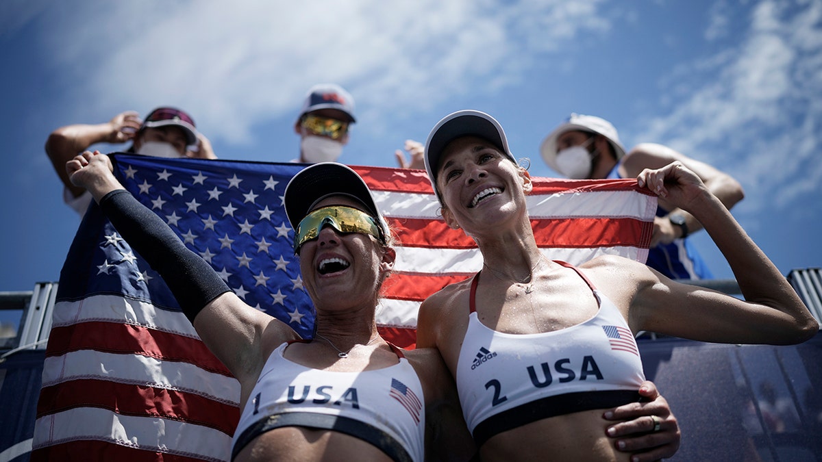 April Ross, left, of the United States, and teammate Alix Klineman celebrate winning a women's beach volleyball Gold Medal match against Australia at the 2020 Summer Olympics,