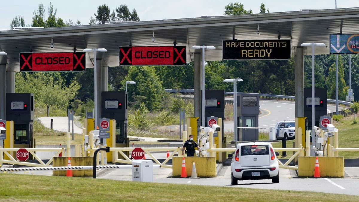 In this June 8, 2021, photo, a car approaches one of the few lanes open at the Peace Arch border crossing into the U.S. in Blaine, Wash. Blaine Chamber of Commerce board member Carroll Solomon called Canada's reopening a step in the right direction for businesses. 