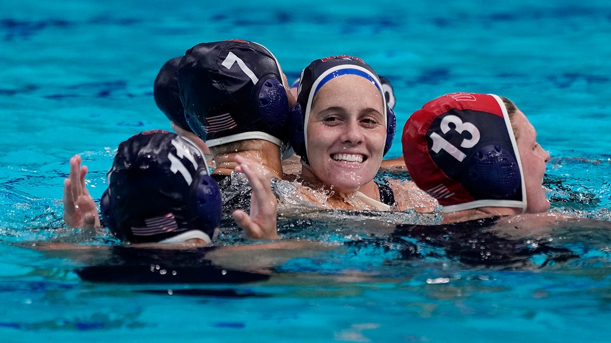 United States' Alys Williams, center, celebrates with teammates after beating Spain in the women's water polo gold medal match at the 2020 Summer Olympics