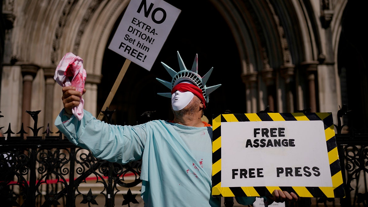 A supporter of WikiLeaks founder Julian Assange demonstrates dressed as the Statue of Liberty, during the first hearing in the Julian Assange extradition appeal, at the High Court in London, on Wednesday. Britain's High Court has granted the U.S. government permission to appeal a decision that WikiLeaks founder Julian Assange cannot be sent to the United States to face espionage charges.