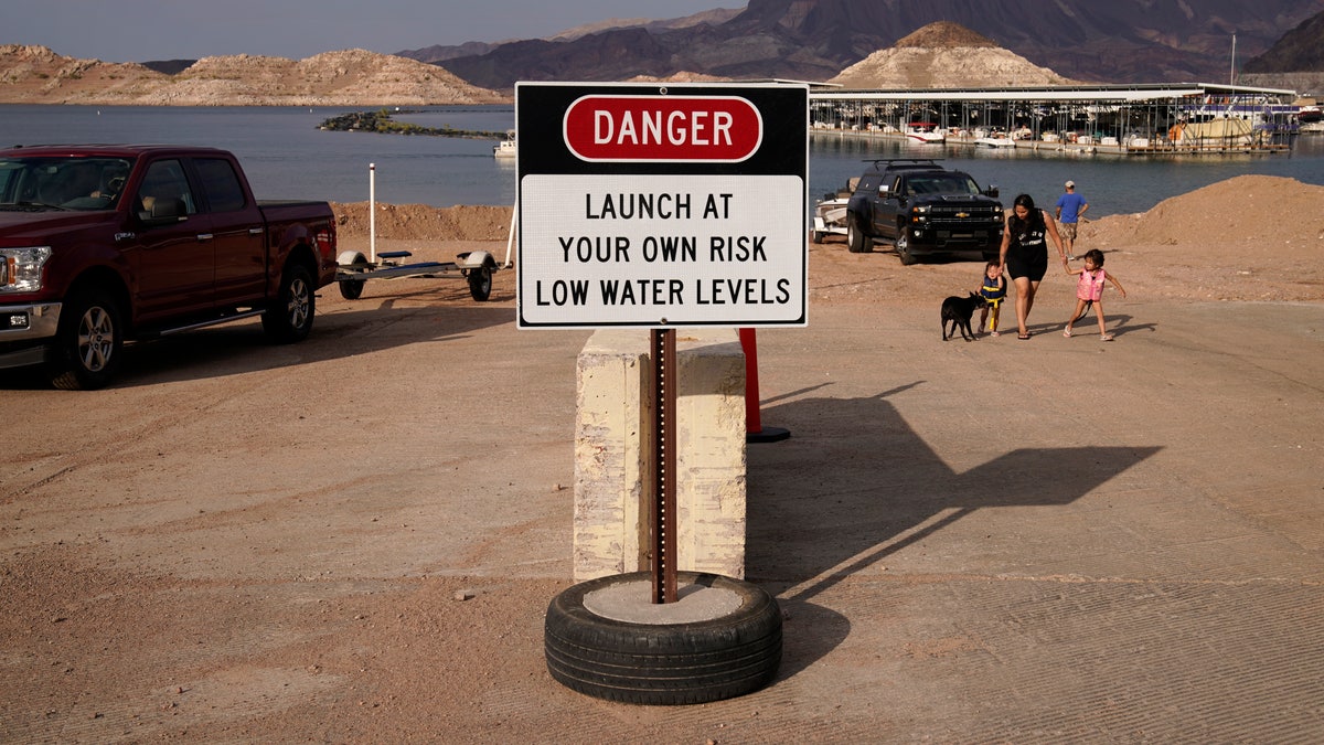 A sign warns of low water levels at a boat ramp on Lake Mead at the Lake Mead National Recreation Area, Friday, Aug. 13, 2021, near Boulder City, Nev. Water levels at Lake Mead, the largest reservoir on the Colorado River, have fallen to record lows. (AP Photo/John Locher)