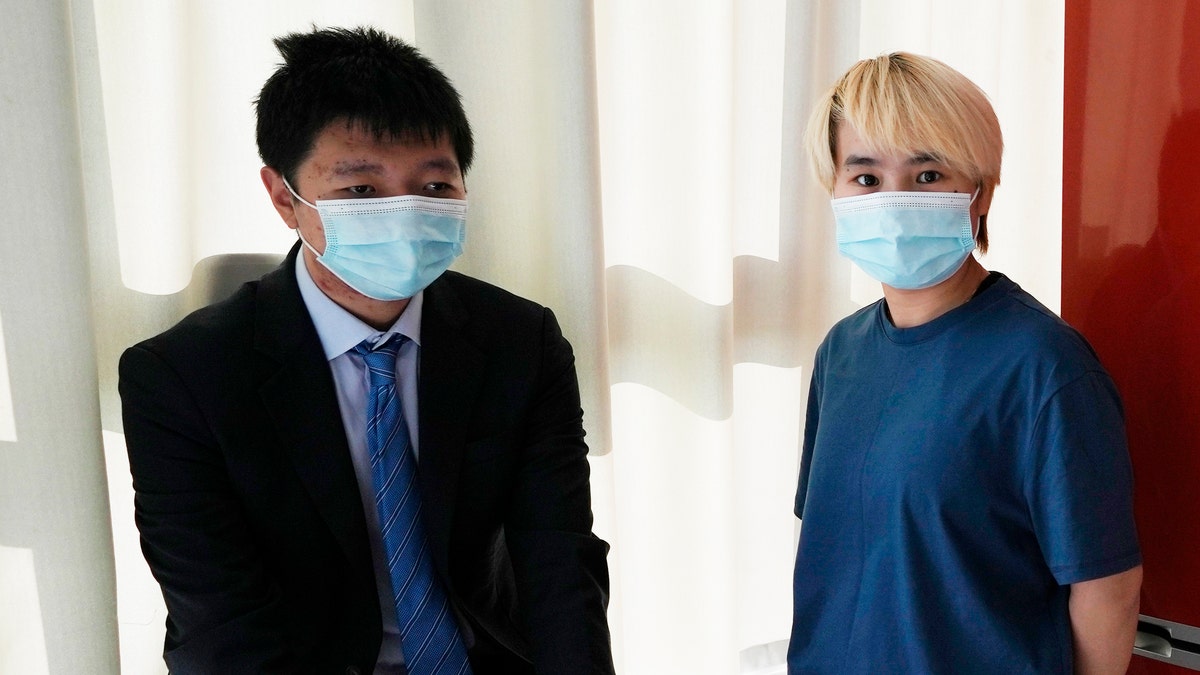 Wu Huan, right, and Wang Jingyu stand together in a safe house in the Ukraine on Wednesday, June 30, 2021. Wu claims that she was held for eight days at a Chinese-run "black site" in Dubai along with at least two Uyghurs, in what may be the first evidence that China is operating a secret detention facility beyond its borders. She was on the run from the threat of being sent back to her home country because of her support of her fiance, Wang, a perceived Chinese dissident. (AP Photo)