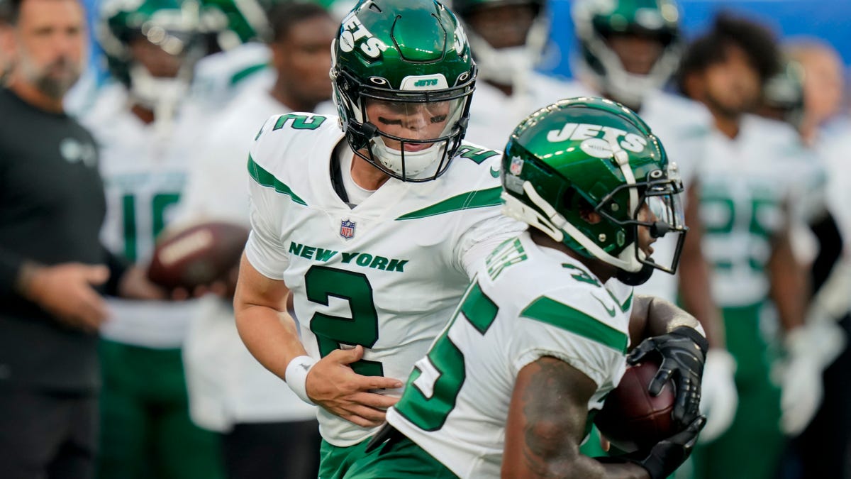 New York Jets quarterback Zach Wilson (2) hands the ball off to running back Austin Walter (35) as players warm up for an NFL preseason football game against the New York Giants, Saturday, Aug. 14, 2021, in East Rutherford, N.J. (AP Photo/Frank Franklin II)