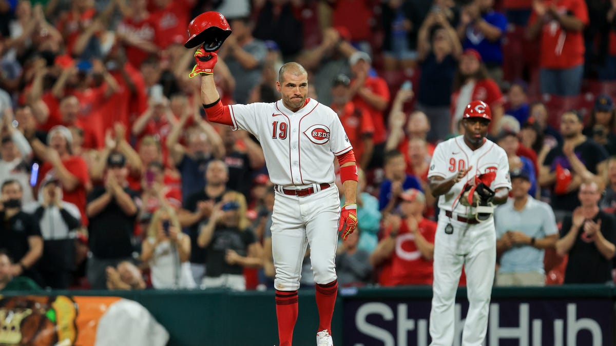 Cincinnati Reds' Joey Votto (19) acknowledges the crowd after hitting a single during the seventh inning of a baseball game against the Chicago Cubs in Cincinnati, Monday, Aug. 16, 2021. The hit was the 2,000th of his career. (AP Photo/Aaron Doster)