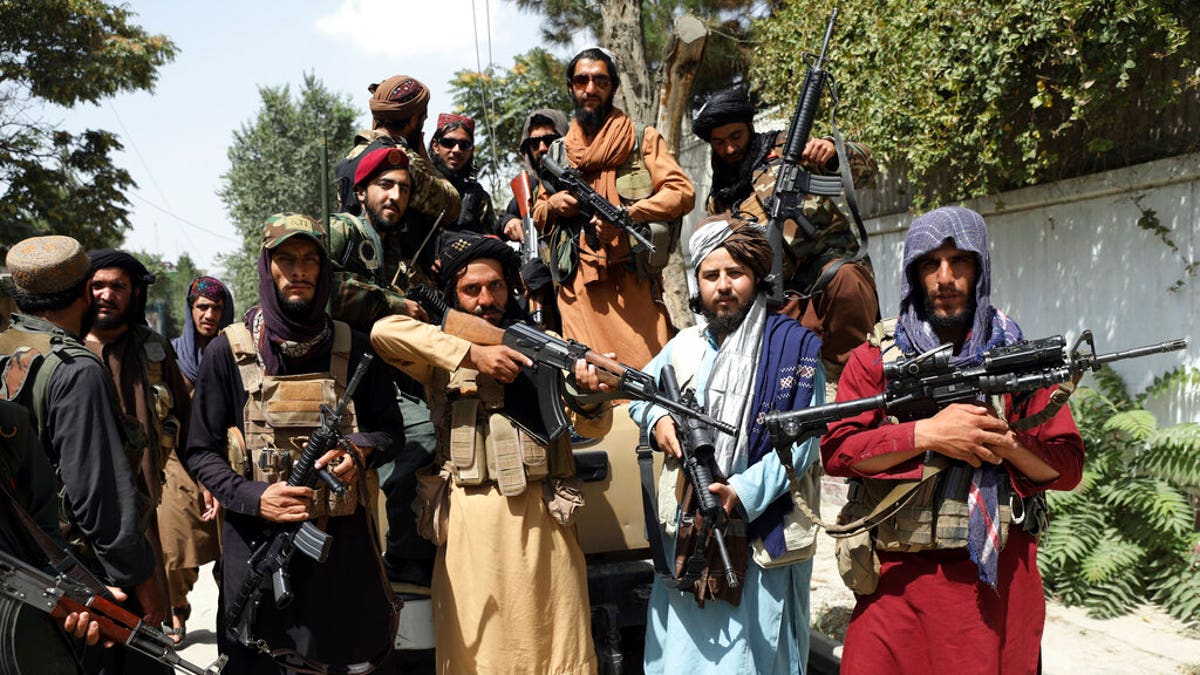 Armed Taliban fighters pose for a photograph