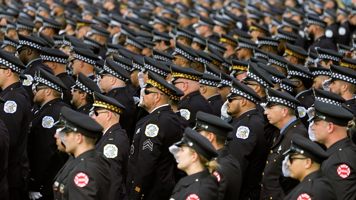 Chicago police and firefighters salute as the body of slain Chicago police officer Ella French is carried into the St. Rita of Cascia Shrine Chapel for a funeral service Thursday, Aug. 19, 2021, in Chicago. 