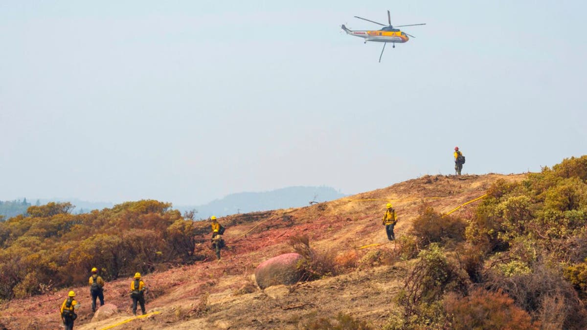 More than 13,500 firefighters were working to contain a dozen large California wildfires that have destroyed hundreds of homes and forced thousands of people to flee to safety.