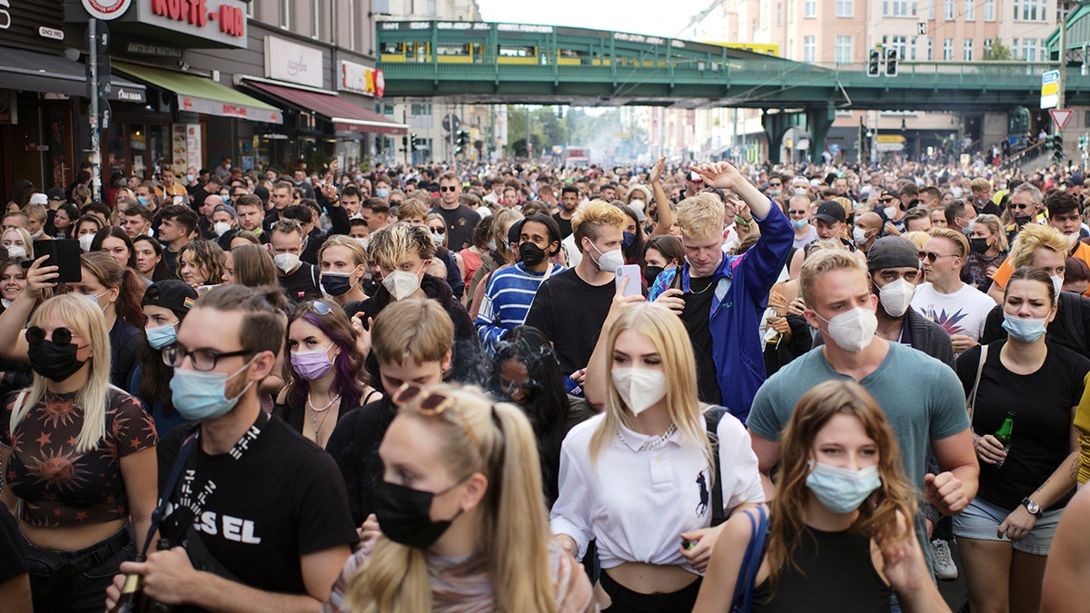 People, most of them wearing masks, dance behind a truck as they attend a demonstration named 'Train of Love' in Berlin, Germany, Saturday, Aug. 28, 2021.?