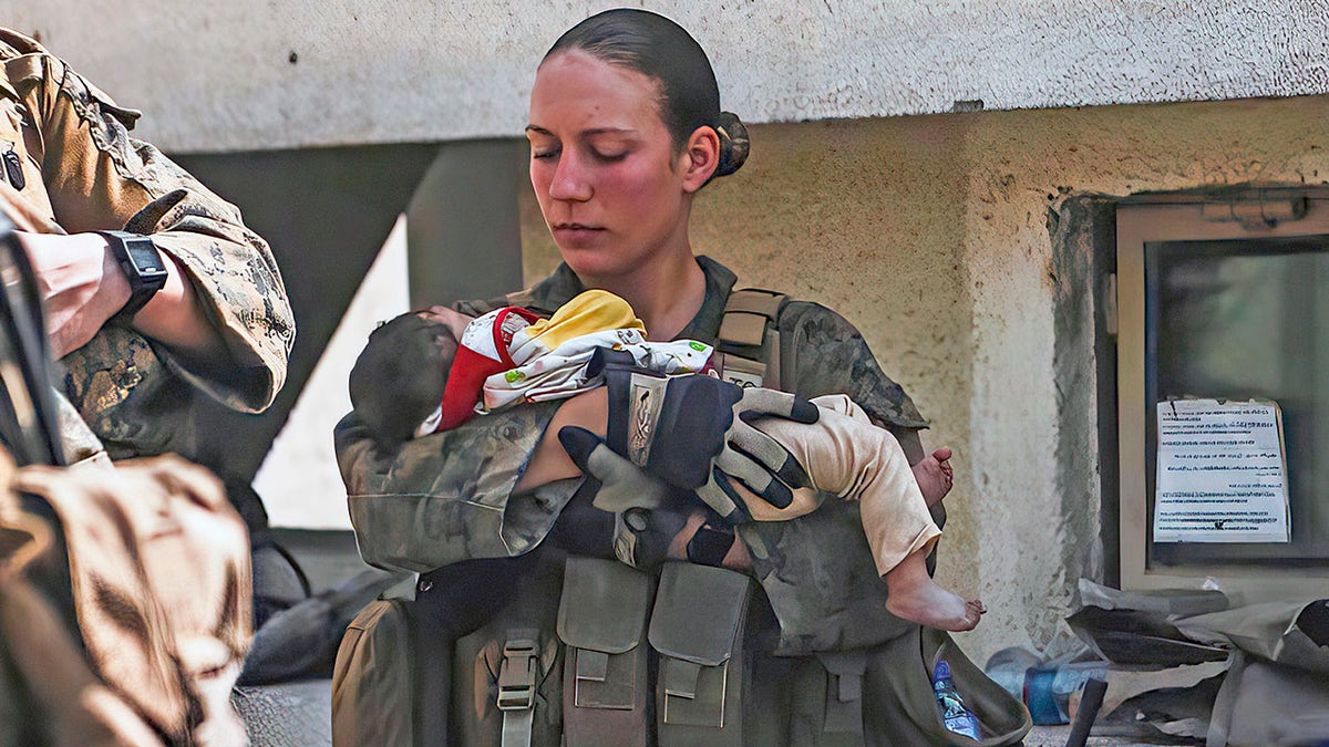 Sgt. Nicole Gee calms an infant during an evacuation at Hamid Karzai International Airport in Kabul, Afghanistan. Officials said that Gee, of Sacramento, California, was one of the Marines killed in the bombing at the airport.