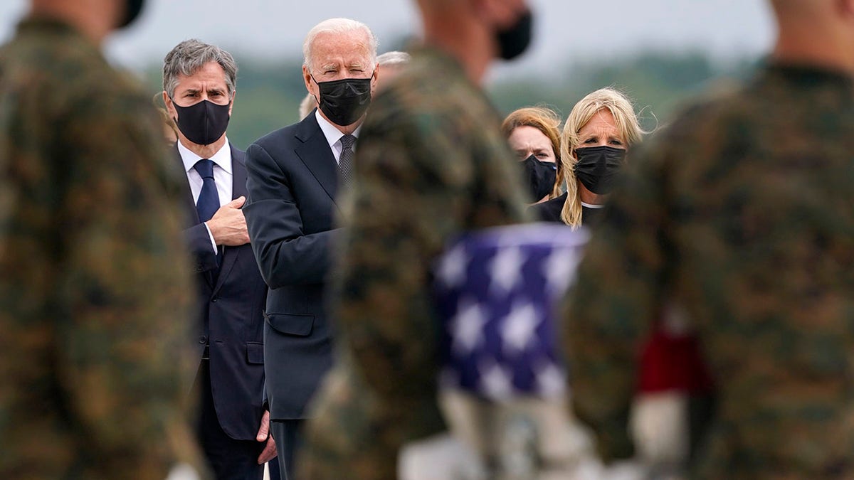 President Biden looks on at carry team transporting military fallen