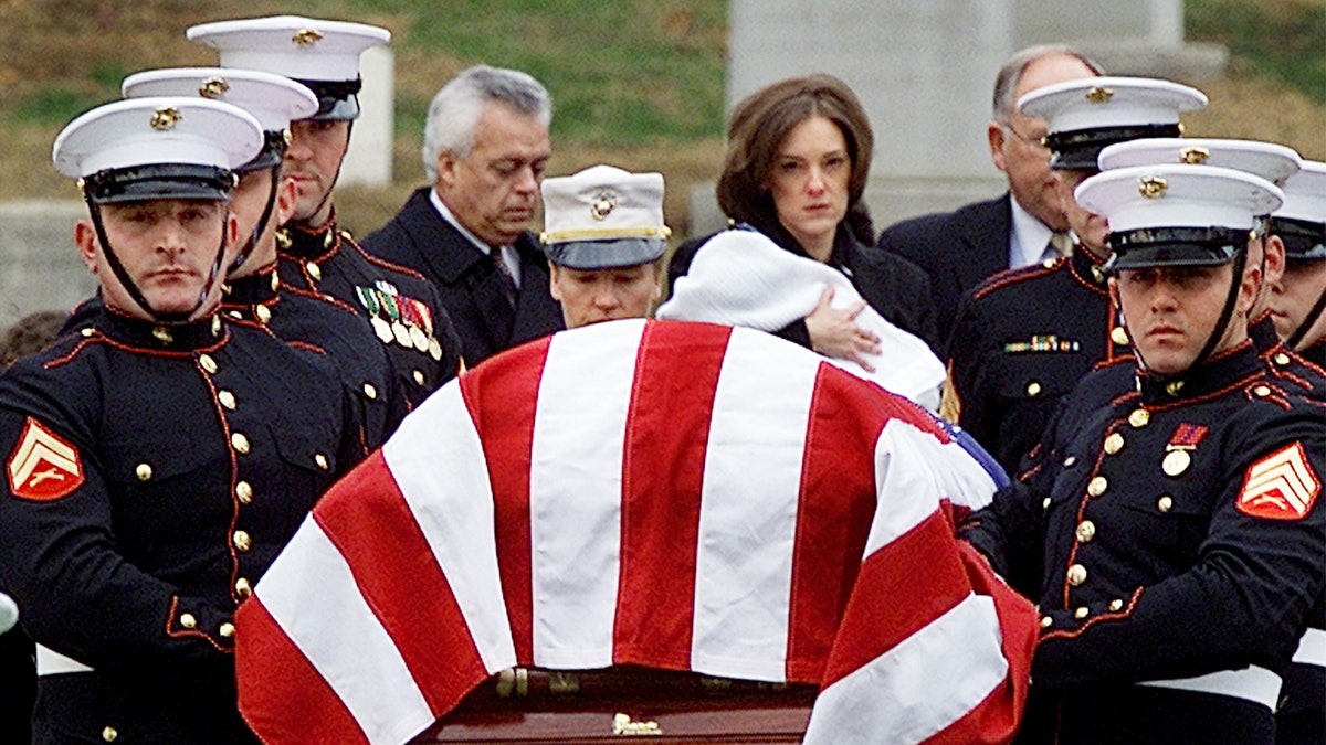 Shannon Spann, wife of CIA officer Johnny Michael "Mike" Spann, follows her husband's casket while holding her 6-month old son Jake, at Arlington National Cemetery in Virginia, on Dec. 10, 2001. 